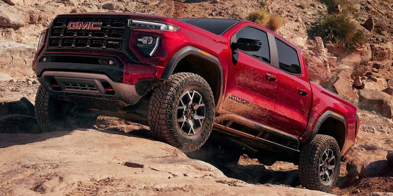 2026 GMC Canyon driving on off-road terrain.