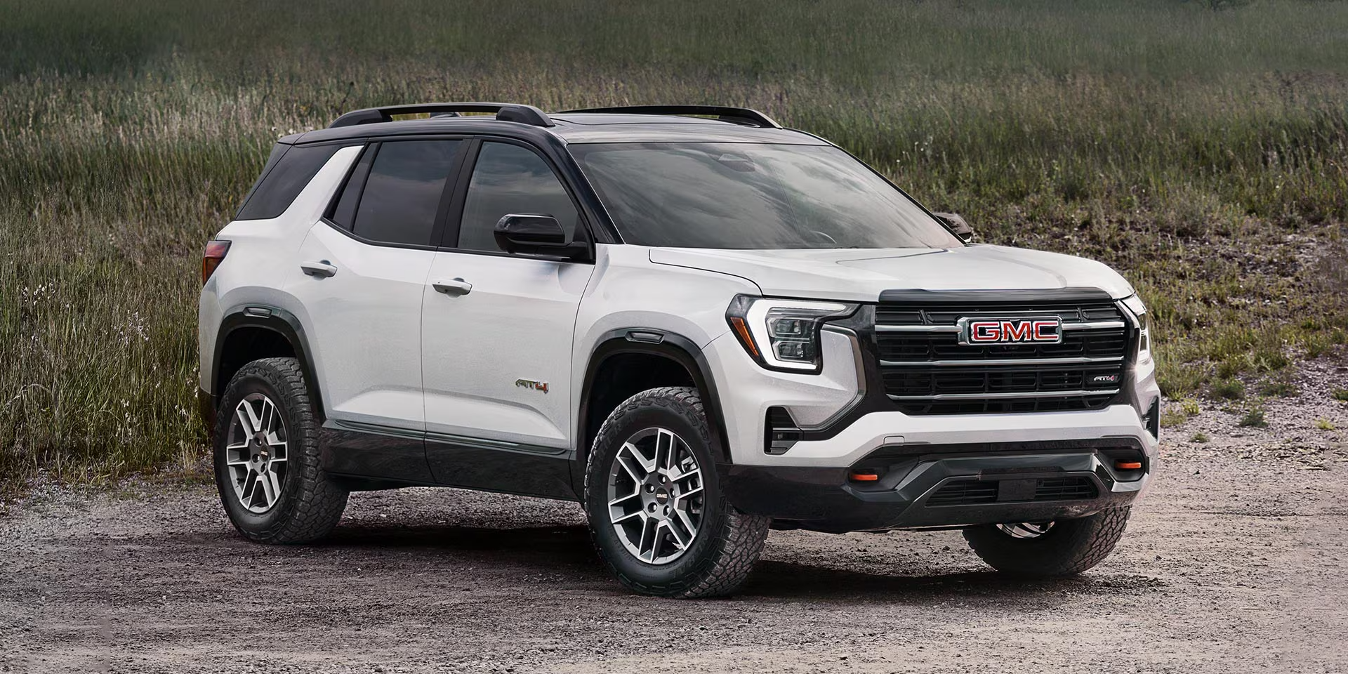 Front three-quarter view of the 2027 GMC Terrain AWD in white parked on a gravel road with a natural landscape backdrop. Interior Image (Cabin Seating)